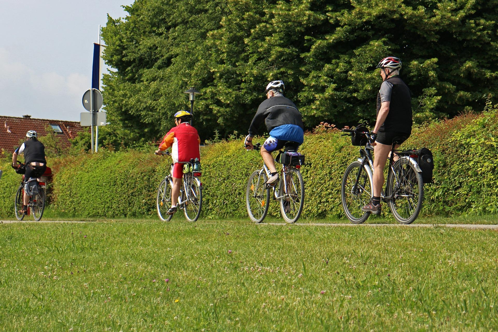 politica de acessibilidade: 4 pessoas pedalando, todas estão equipadas com equipamentos de segurança, capacete e tornozeleiras.